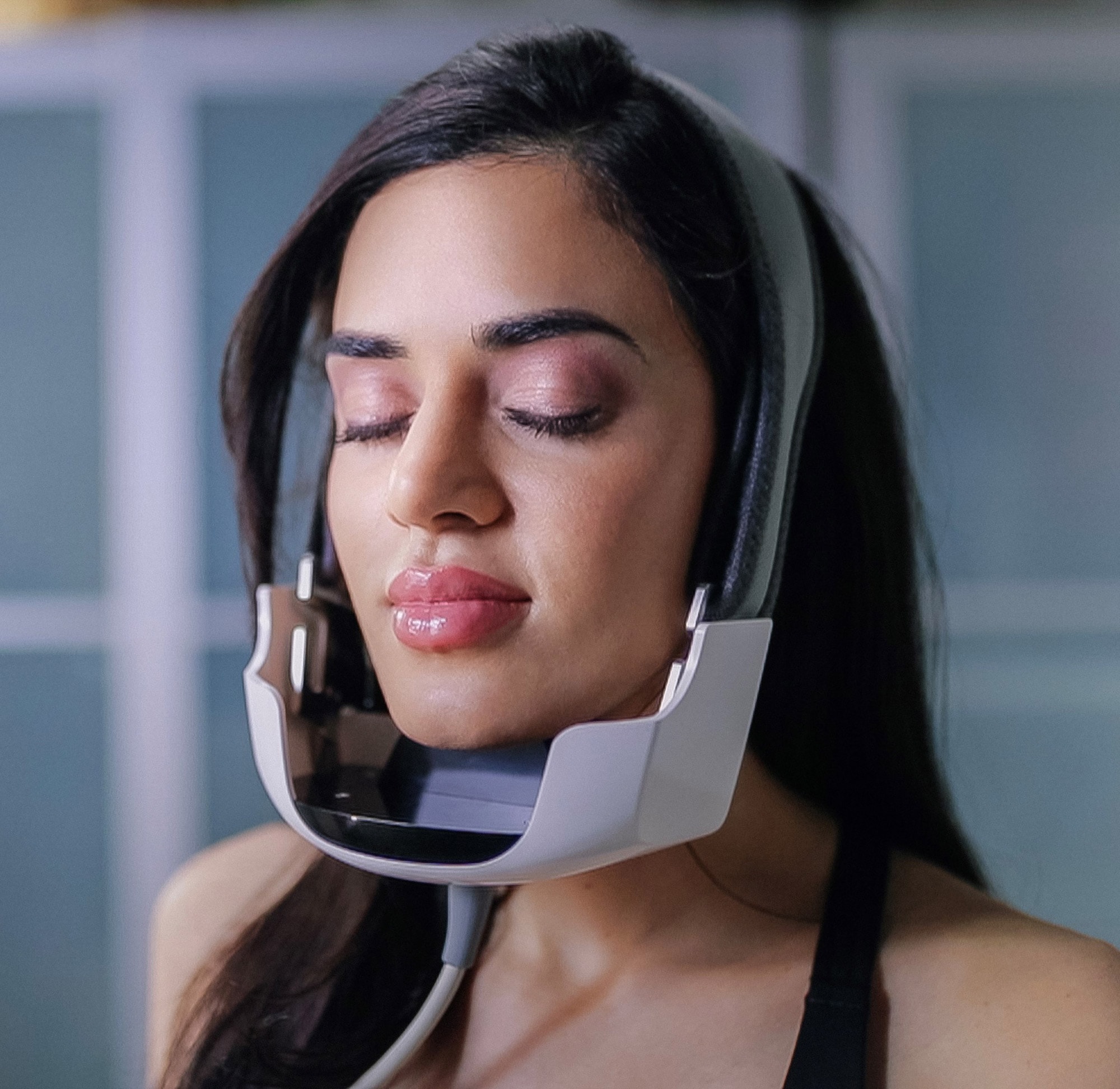 Woman with the Evoke machine on her chin facing left with her eyes closed