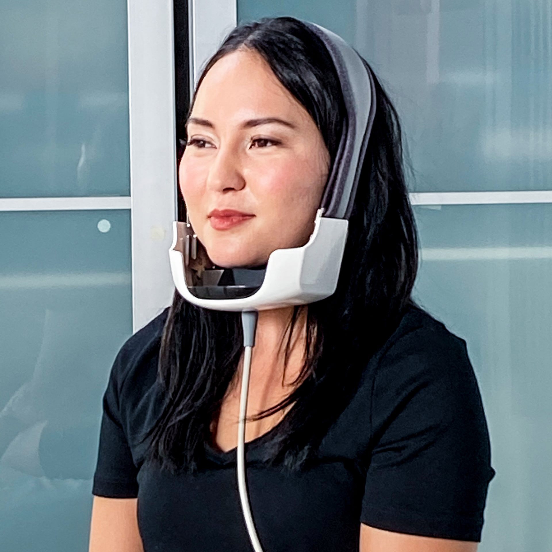 Woman with the Evoke machine on her chin facing left with her eyes closed