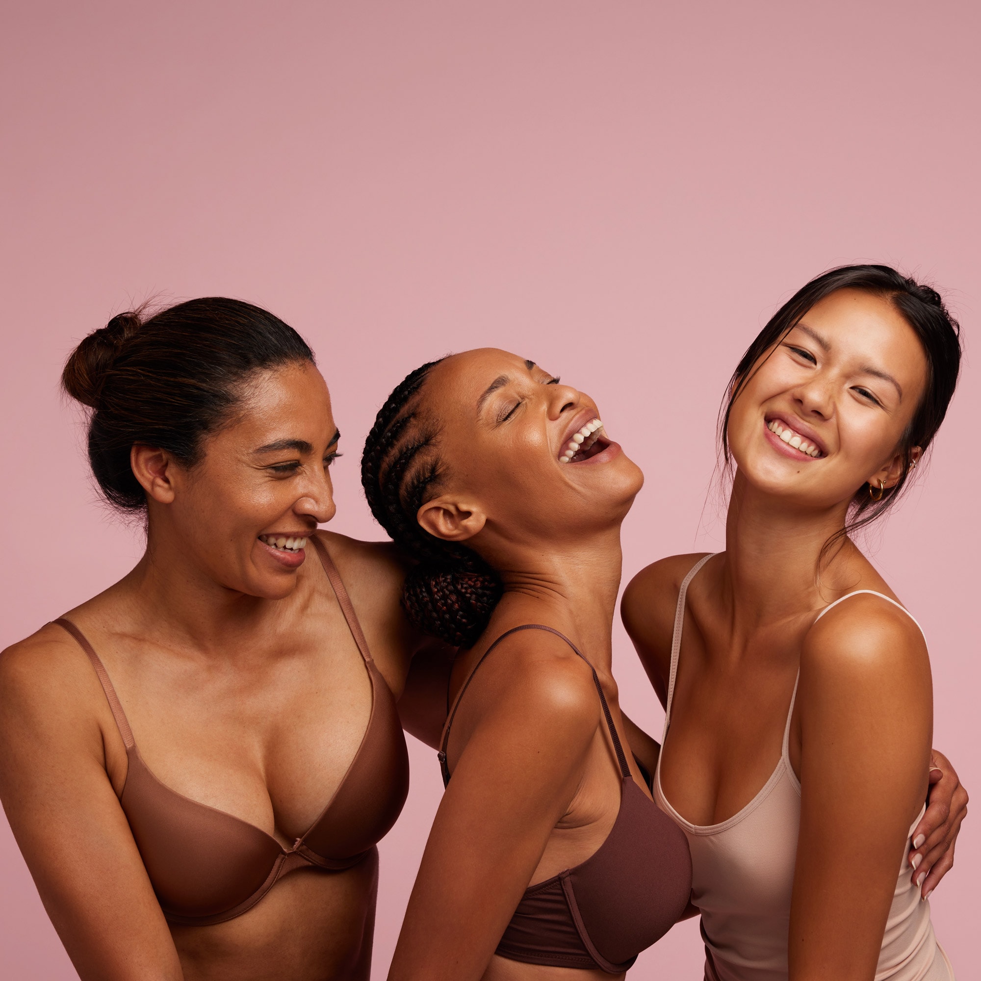 Three women in lingerie laughing and smiling